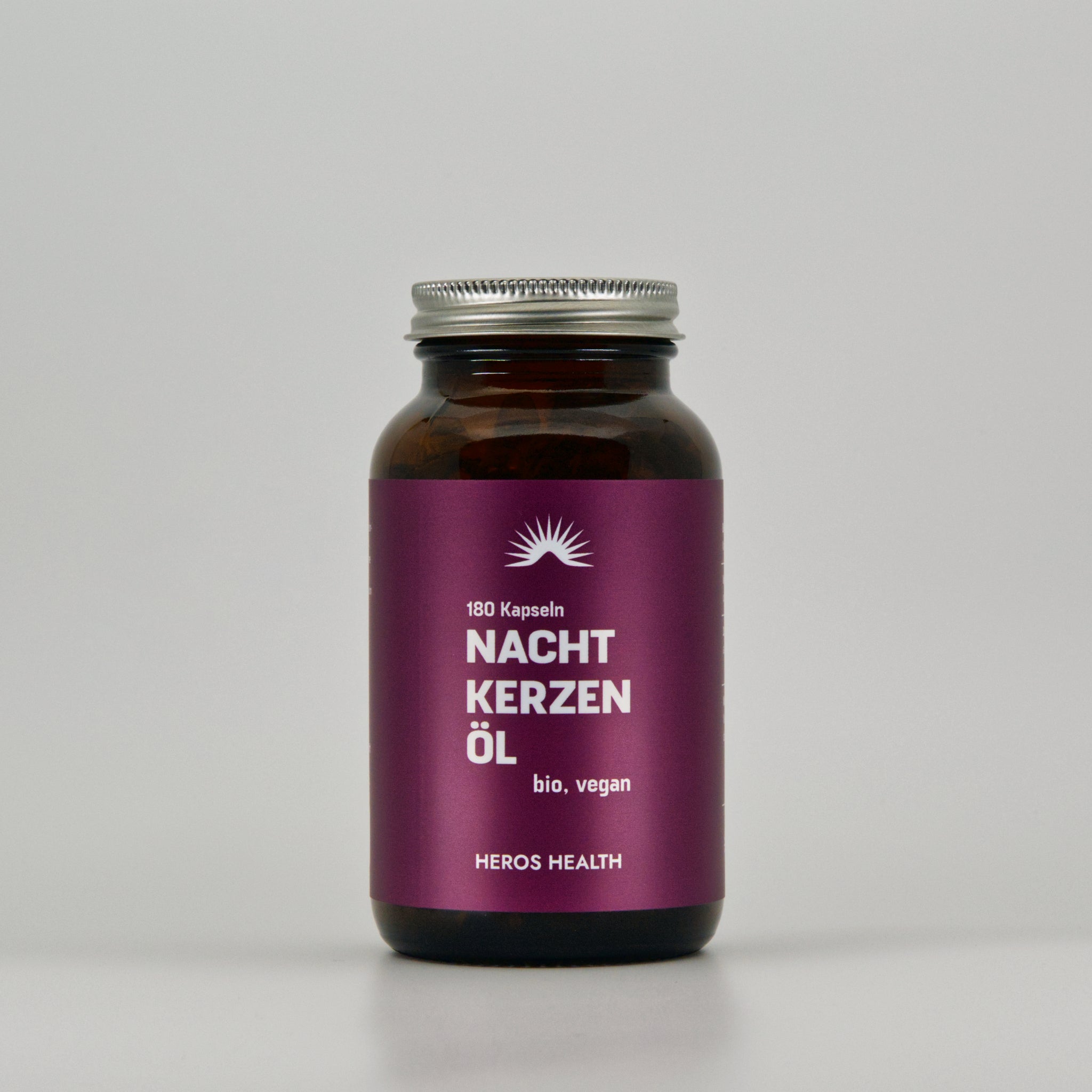 front view of amber glass with organic evening primrose oil capsules on light background 